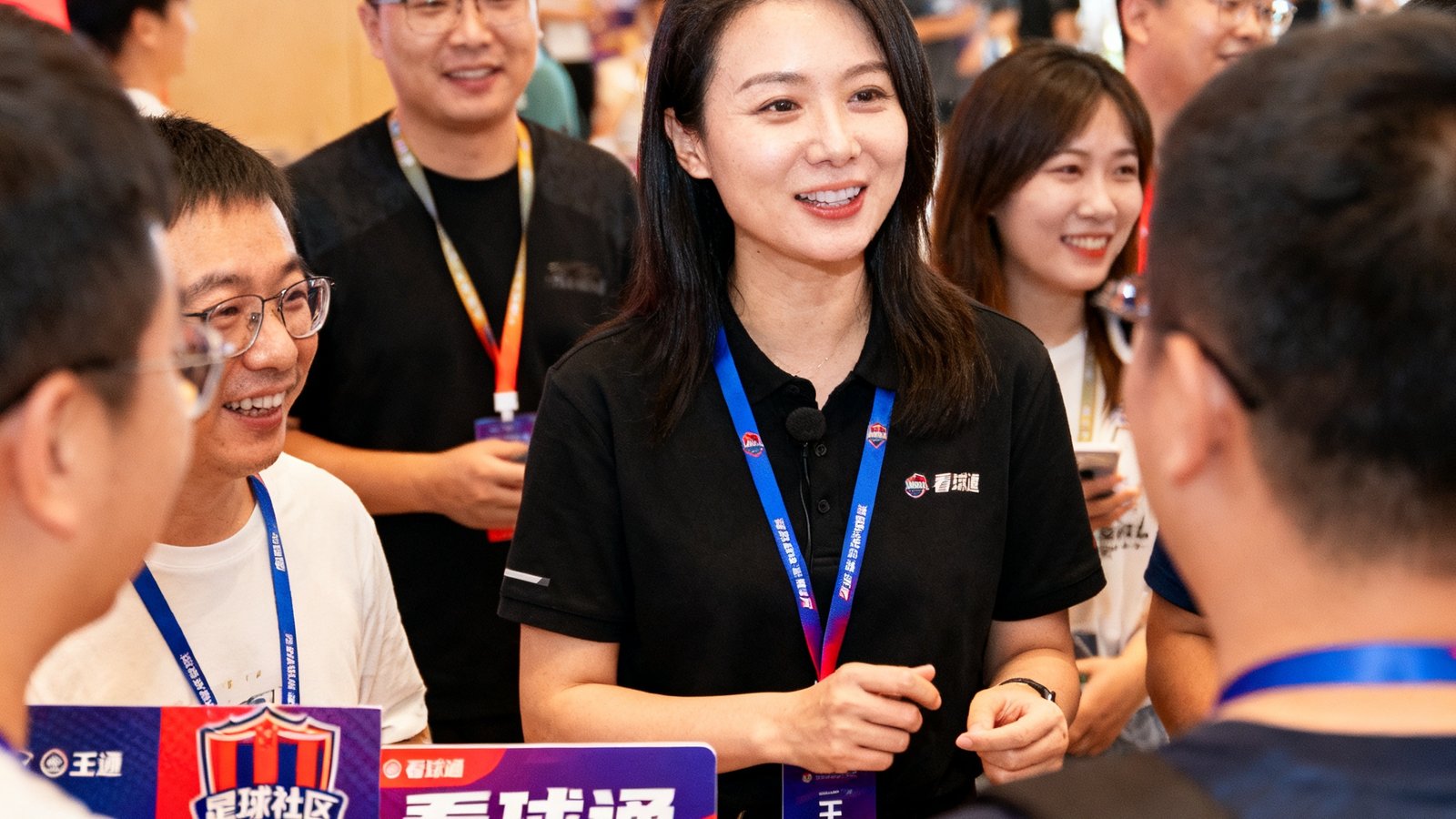 运营总监王璐在球迷社区活动中与用户互动，周边展示看球通品牌